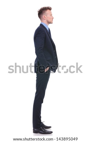 full length side view picture of a young business man standing with his hands in his pockets and looking forward. on white background