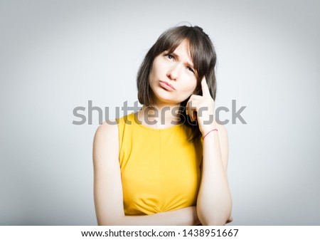 beautiful young woman thinks about a problem, isolated on background