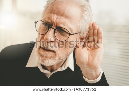 Portrait of senior man having hearing problems Royalty-Free Stock Photo #1438971962