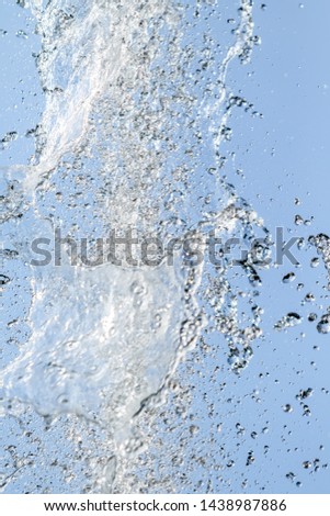 Splashes of water. Fountain, a jet of water against the blue sky.