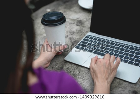 Business woman hands holding coffee cup and using laptop computer, Back view.
Rear view of woman sitting at desk using laptop trackpad surfing internet, working on notebook blank screen.