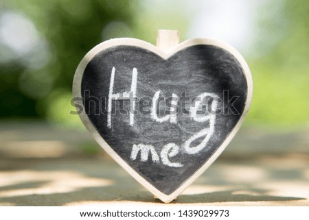 Hug me - hand drawing phrase on a heart, Sharing a Hug concept