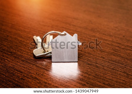 The symbol of the house lies on a brown wooden background 