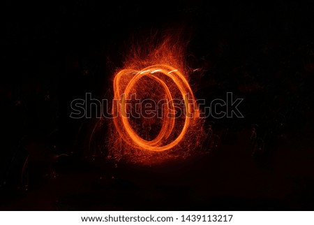 Round sparkling fire formed by a fire dancer 