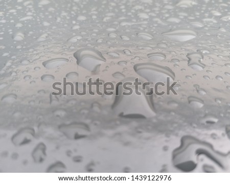 Water rain drops on the car hood. Gray background