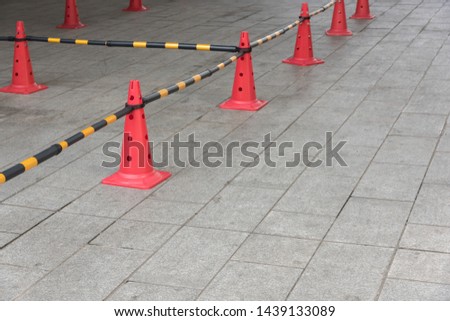 There are many red plastic road cones on the square open space to isolate the chaotic crowd and maintain good order.