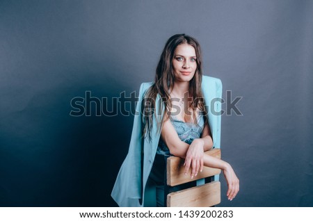 Young female business coach. Jacket draped over her shoulders. Modern business woman in blue suit. Total look