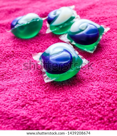 Laundry Day - laundry detergent pods on a laundry folding table with pink towels.