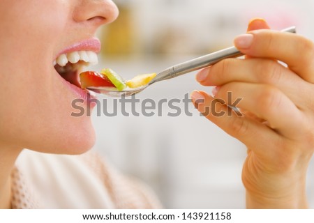 Closeup on woman eating fruits on spoon Royalty-Free Stock Photo #143921158