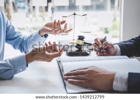 Consultation and conference of Male lawyers and professional businesswoman working and discussion having at law firm in office. Concepts of law, Judge gavel with scales of justice. Royalty-Free Stock Photo #1439212799