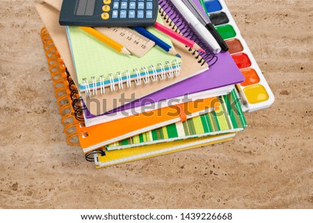 School supplies with calculator and stack notebook