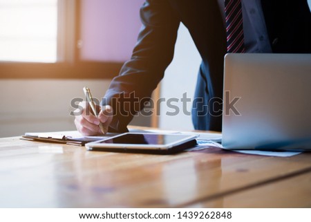 Business concept. Businessman manager working in modern office, make a deal, signing official contract with laptop computer, digital tablet.