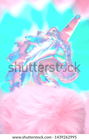 Shiny zine type gradient holographic iridescent head of pink soft fluffy toy unicorn on bright blue background. Celebration or birthday greeting card concept with copy space