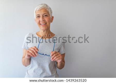 Beautiful mature business woman isolated over grey background. Attractive middle aged woman with beautiful smile. Portrait of mature business woman smile while standing against grey background.