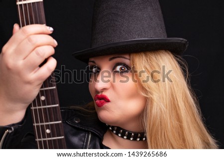 Beautiful blonde girl in rock style on a black background