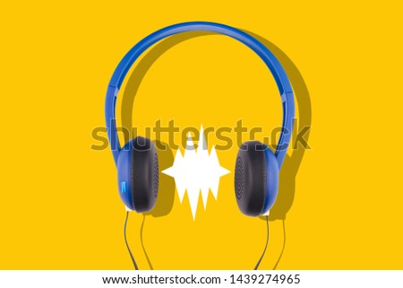 3d illustration front view closeup of black and blue headphones isolated on yellow background with empty comic sound speech bubble 