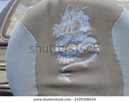 car seat with blue embroidery dragon symbol on the back