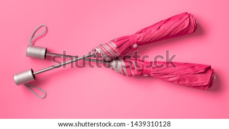 Pink umbrella on blue color background with space for design,top view