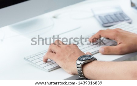 Businessman using computer keyboard. Close up of male hands typing on computer keyboard. Blogger, journalist writing new article. Just hands over the table.