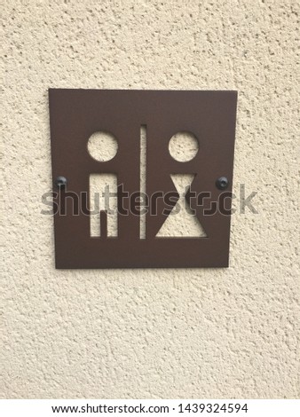 Unique metal sign with cutouts of a man and woman to alert you to where the restrooms, washrooms and or water closets are.
