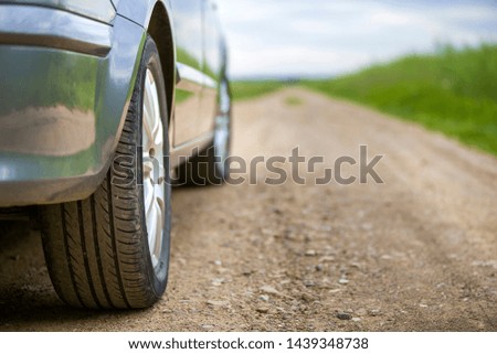 Close-up detail of car part, wheels with aluminum disc and black rubber tire protector on light outdoors background. Traveling and vehicles concept.
