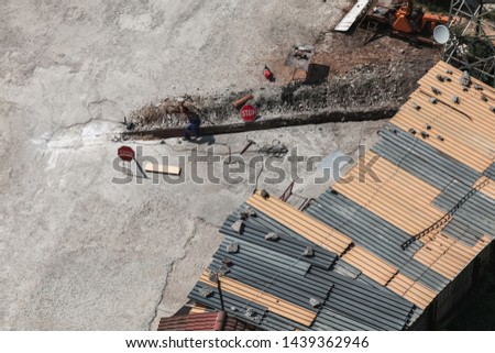 Man at work. Worker digs manually long ditch in urban ground