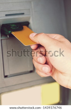 Man hand taking dollar bills out of an ATM
