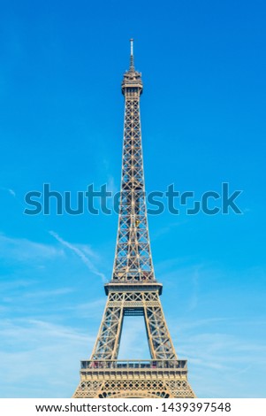 Detailed view of the Eiffel Tower on the background of bright blue sky