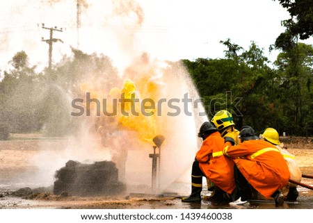 Firefighters training using fire hose and control fire with water
