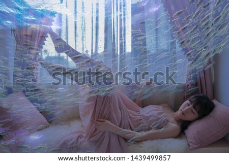 A girl sleeping in a beautiful dream has a beautiful dream about the underwater world.