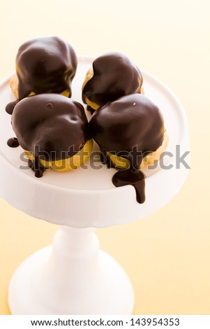 Cream puffs dipped in chocolate at desert bar.