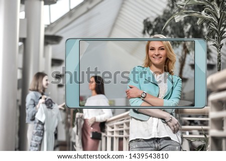 Portrait of beautiful smiling blonde on shopping, concept of new features in smartphone s camera