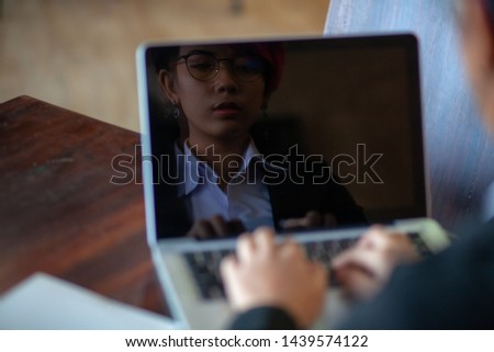 Reflection on the notebook screen Of Asian working women