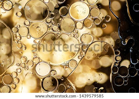Abstract background. Black and yellow oil bubbles on water