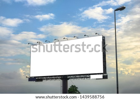 White large empty billboard with steel structure on side of road with blue sky at evening