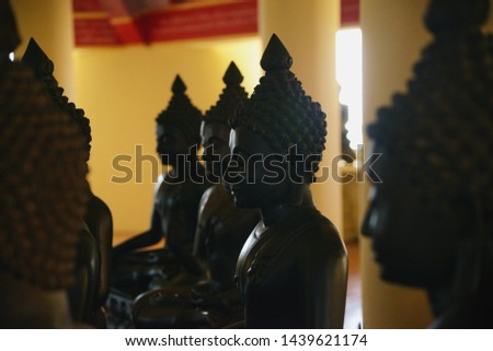 row of Buddha statues in temple of Thailand, close up of head Buddha statue in black color 