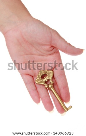 Old metal key in a hand isolated on white