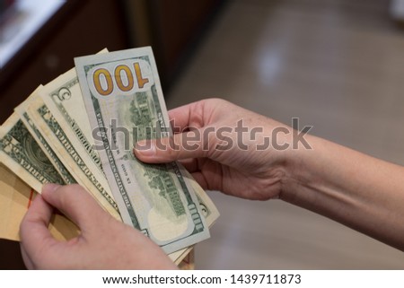 hand paying with cash dollars