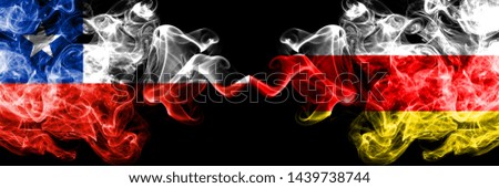 Chile vs South Ossetia smoky mystic flags placed side by side. Thick colored silky smokes combination of South Ossetia and Chilean flag