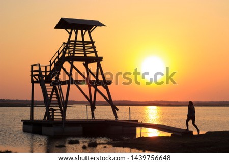 Person goes to the viewing tower. Bird and other wildlife observation tower for tourists in the Engure Lake Nature Park. Fabulous sunset and beautiful colors. Travel and see Latvia and the Baltics