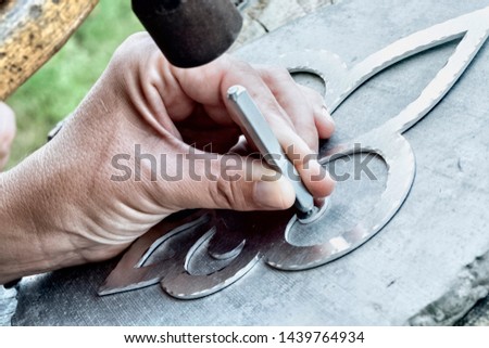 Working with hammer during hand stamping or engraving decoration pattern on metal ornament. Hands detail of craftsman at work. - Image