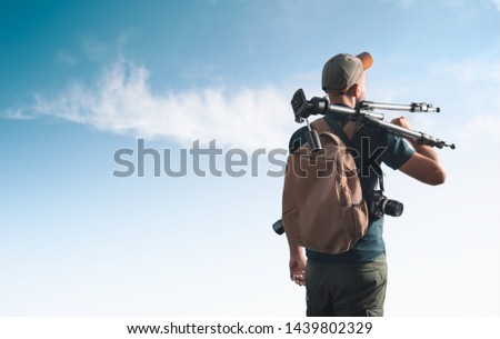 Photographer with photographic equipment. View from the back