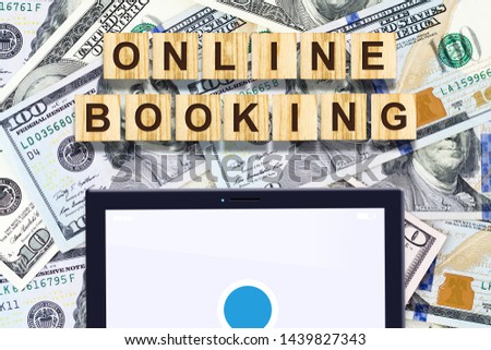 Online booking. The inscription on the wooden blocks, the tablet on the background of dollar bills. Business. Finance.