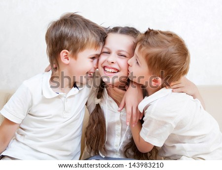 happy brothers kiss the sister