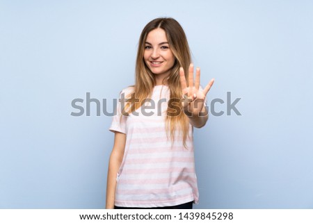 Young woman over isolated blue background happy and counting four with fingers