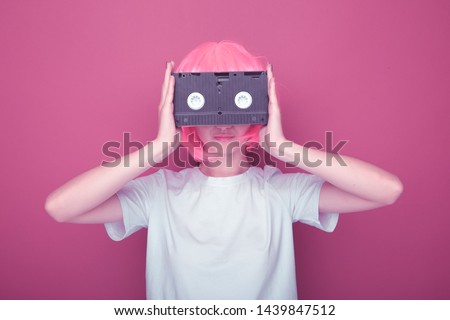 Young girl 90s and VHS cassette on pink
