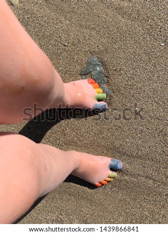 Rainbow baby finger on seа sand