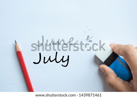 Businessman erasing June text change to July. month and Season change concept