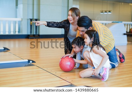 asian family playing bowling together