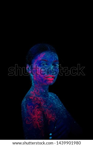 Picture of a pink jellyfish on the shoulder and face. Blue girl alien looks to the camera.  Tilted her head to the shoulder